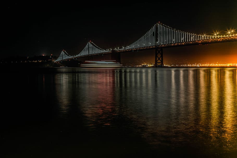 black bridge over body of water during daytime, high bridge with lights during nighttime HD wallpaper