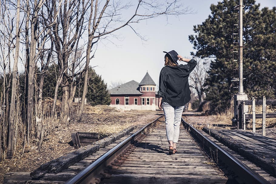 woman wearing black jacket walking on railway, people, lazy, hat