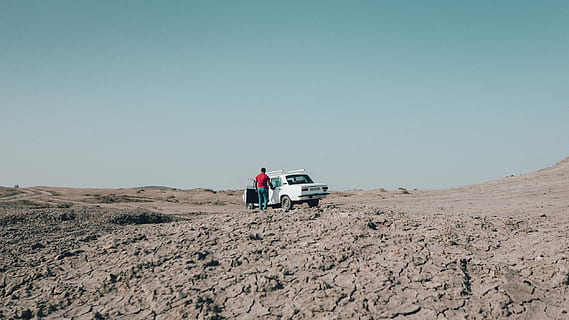 person standing beside Tofas Sahin on dirt road, dessert, lada HD wallpaper