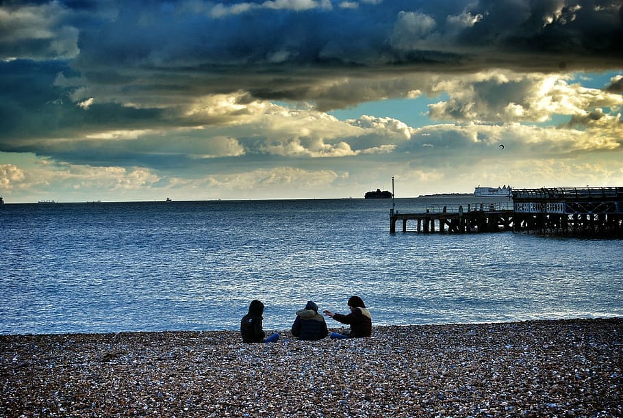 beach, sunset, bridge, sea, sky and clouds, people, stones HD wallpaper