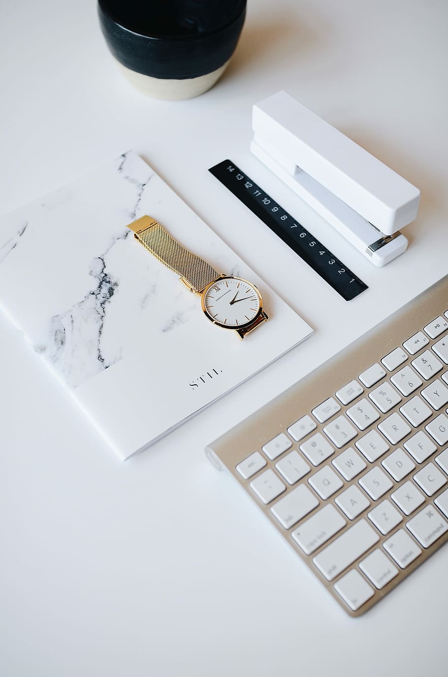 watch on top of book beside stapler near Apple keyboard, round gold-colored analog watch on book HD wallpaper
