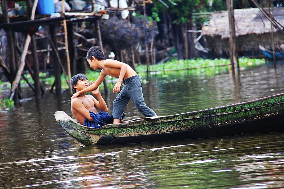 two boys on green boat on body of water, kompong phluk kompong