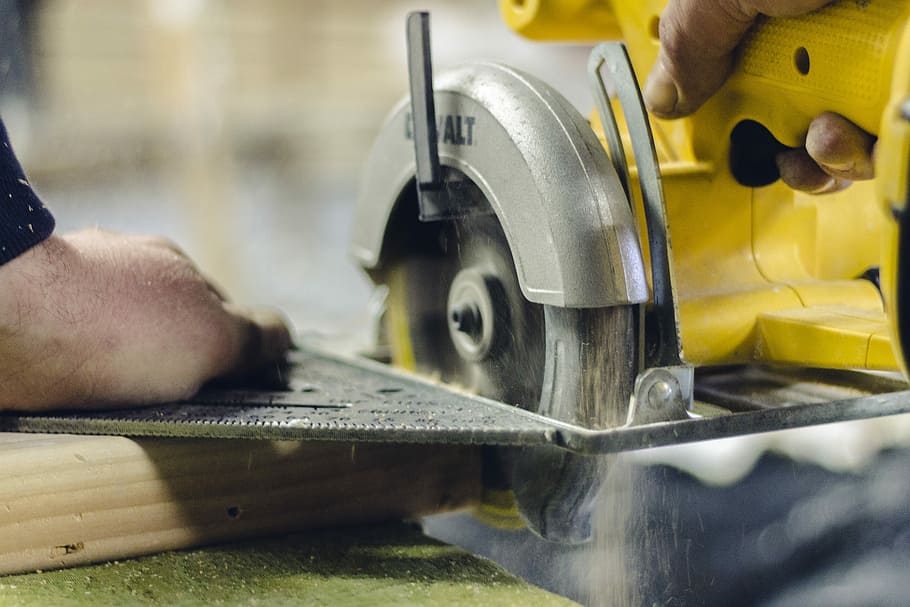 turned-on circular saw, person using DEWALT circular saw, lathe