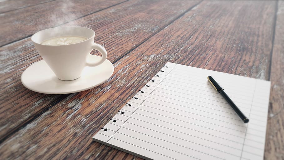 black pen on white lined printer paper near white mug filled with coffee HD wallpaper