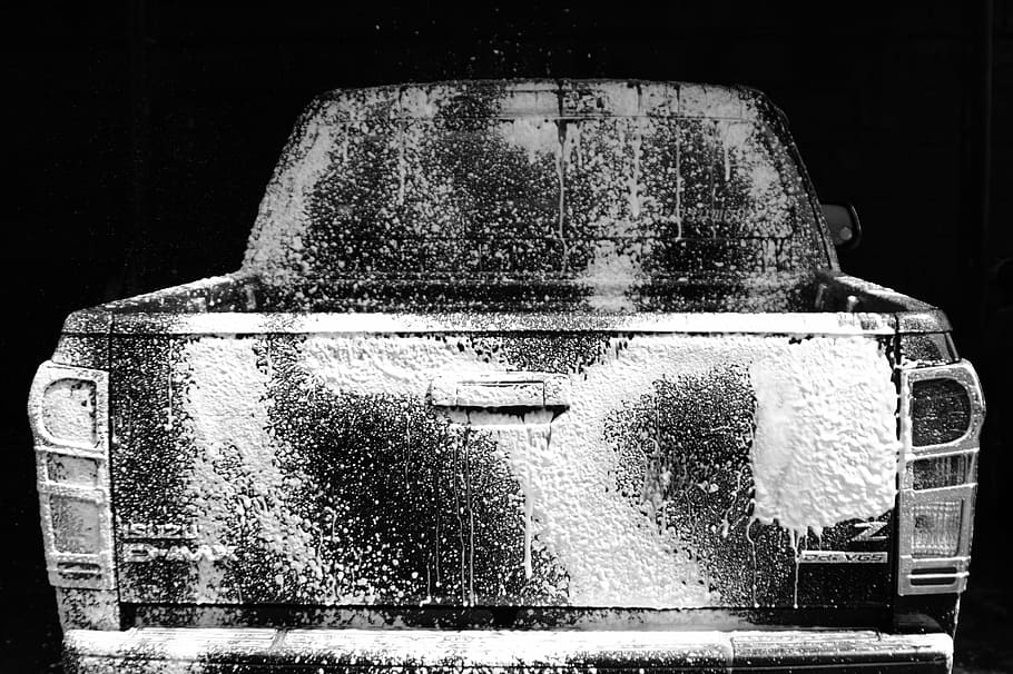 washed black pickup truck in black background, car wash, cleaning