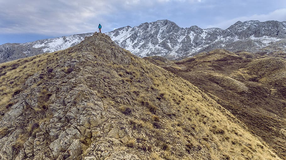 person standing on mountain cliff under clear sky during daytime, person on mountain cliff HD wallpaper