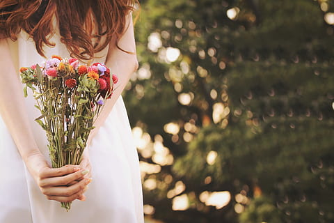 woman holding white dress while holding a red, purple and red flowers HD wallpaper