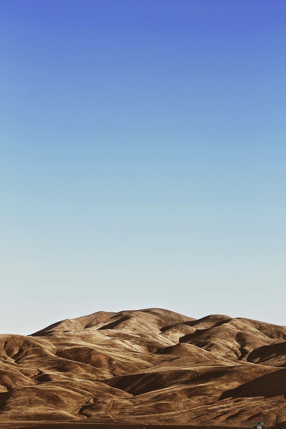 landscape photography of brown mountains, desert under clear sky HD wallpaper
