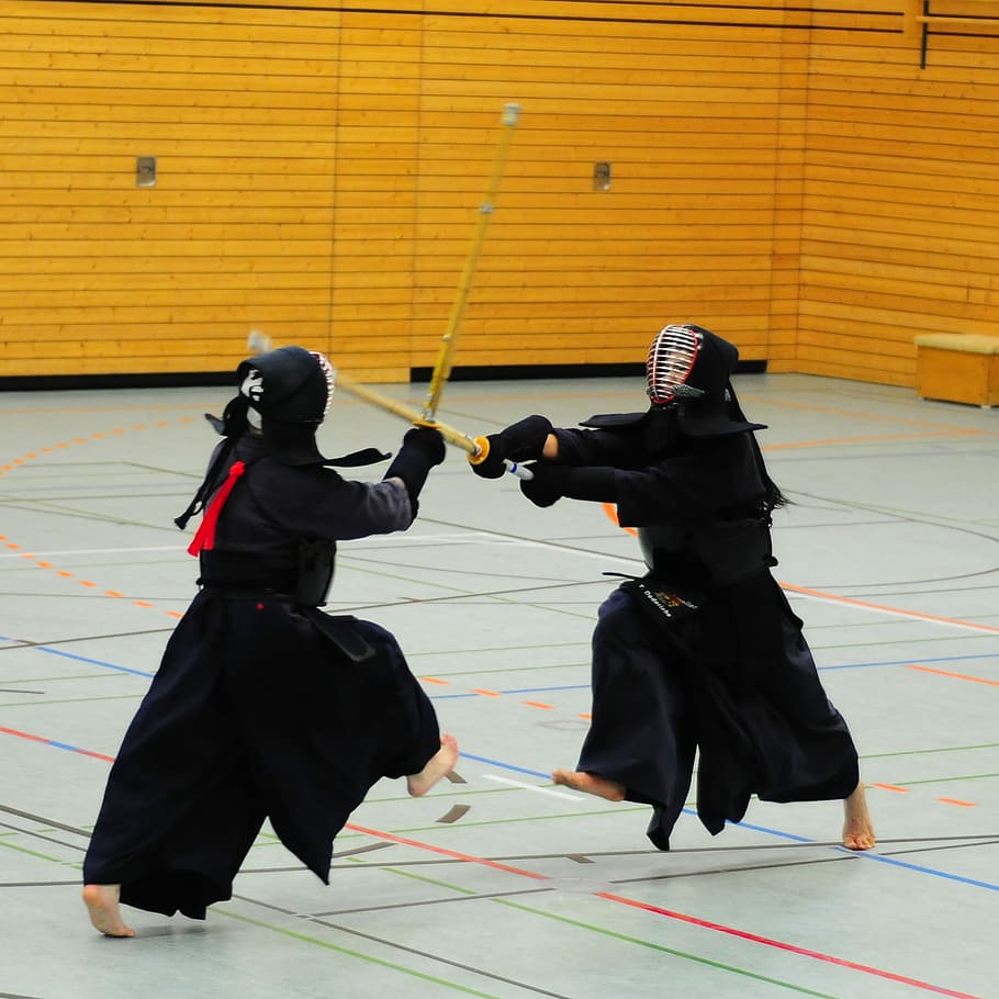 Kendo Competition, two people having a wooden sword sparring indoors