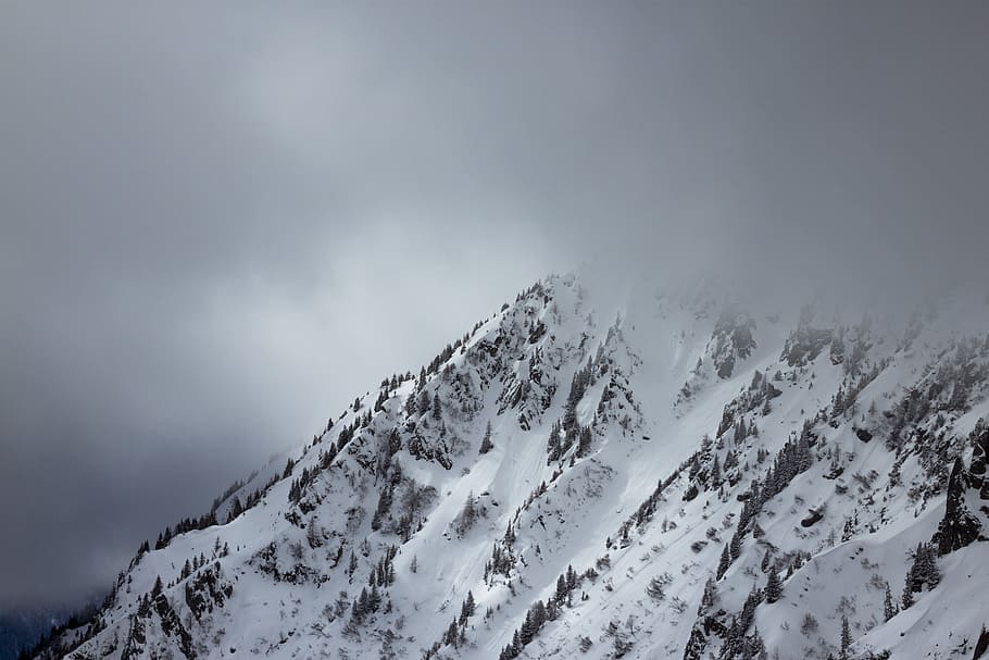 hills covered with snow over nimbus clouds, aerial view of mountain peak HD wallpaper