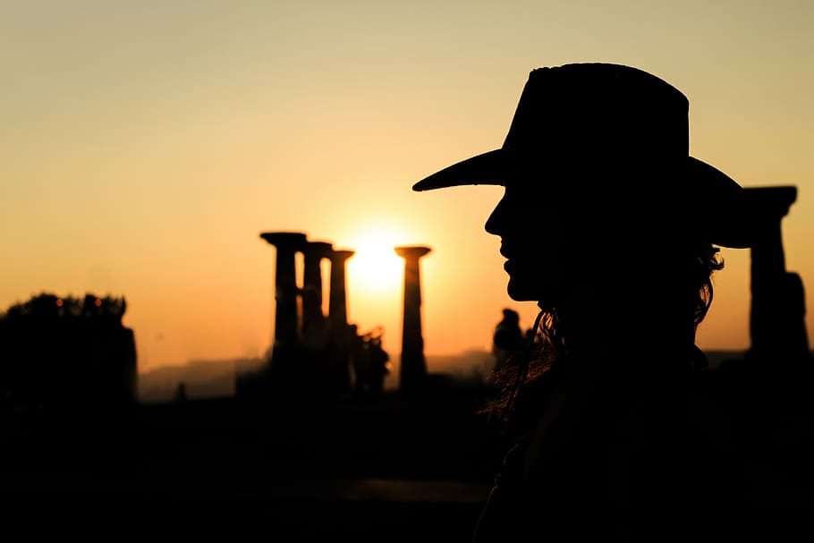 silhouette photography of person wearing cowboy hat, sunset, solar