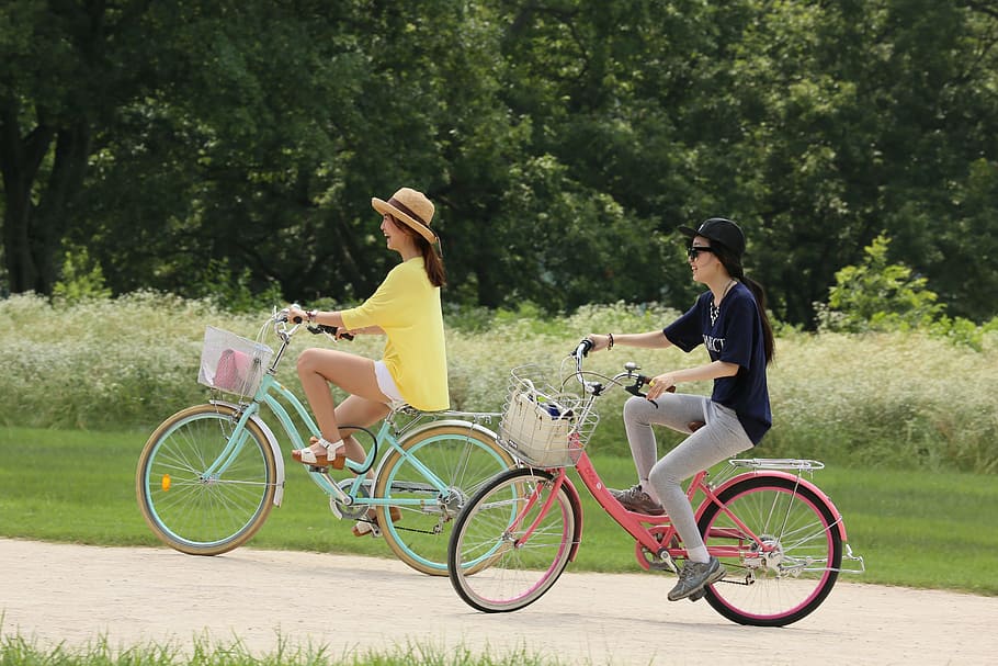 two women riding bicycles during daytime, bike, cyclist, man