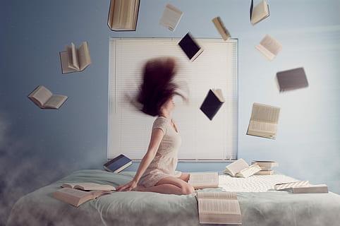 woman in white dress throwing assorted books while whipping her hair on bed HD wallpaper