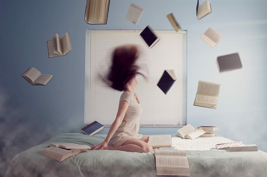 woman in white dress throwing assorted books while whipping her hair on bed HD wallpaper
