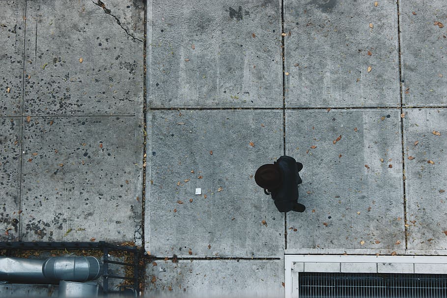 aerial photography of person standing near concrete building, person walking on gray concrete walkway HD wallpaper