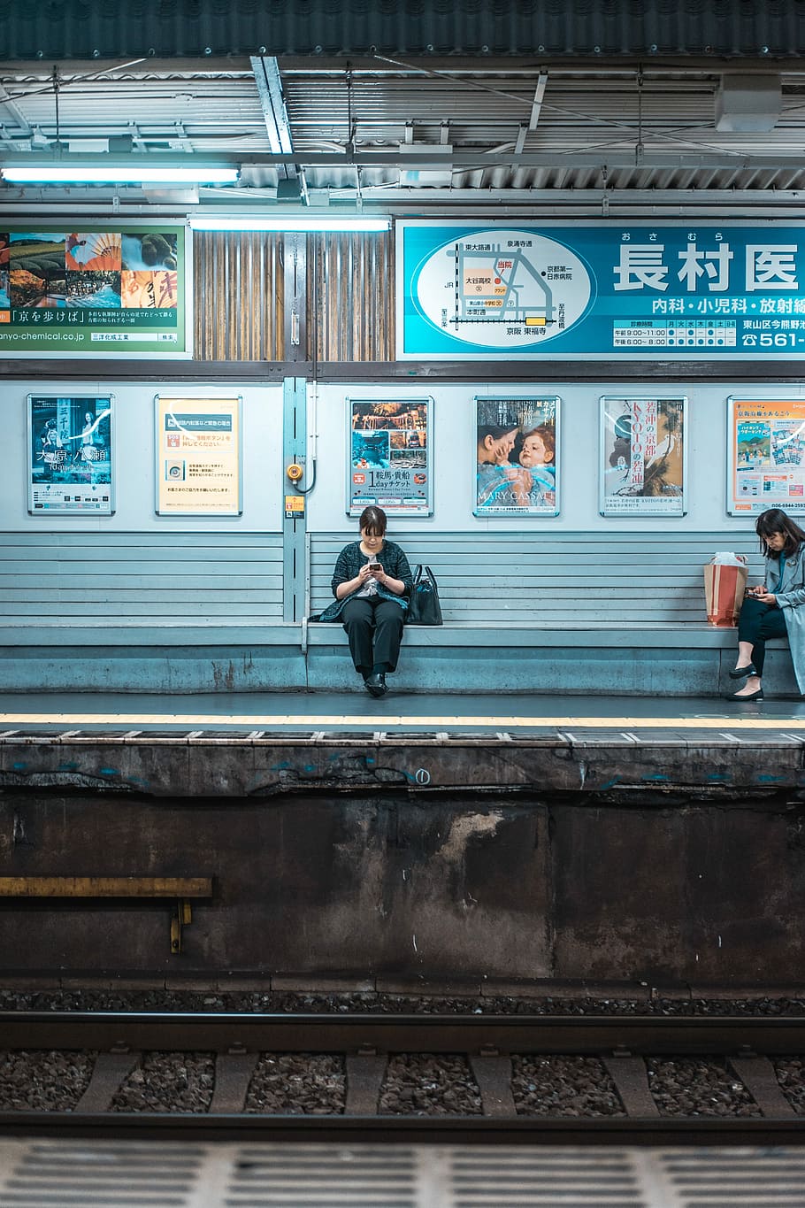 woman sitting on bench while using phone, woman sitting of train bench while using phone, HD wallpaper