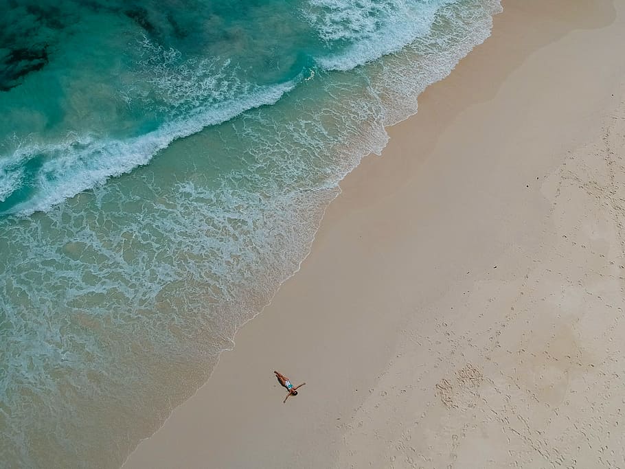 birds eye photography of person near body of water, aerial view photography of person laying on seashore HD wallpaper