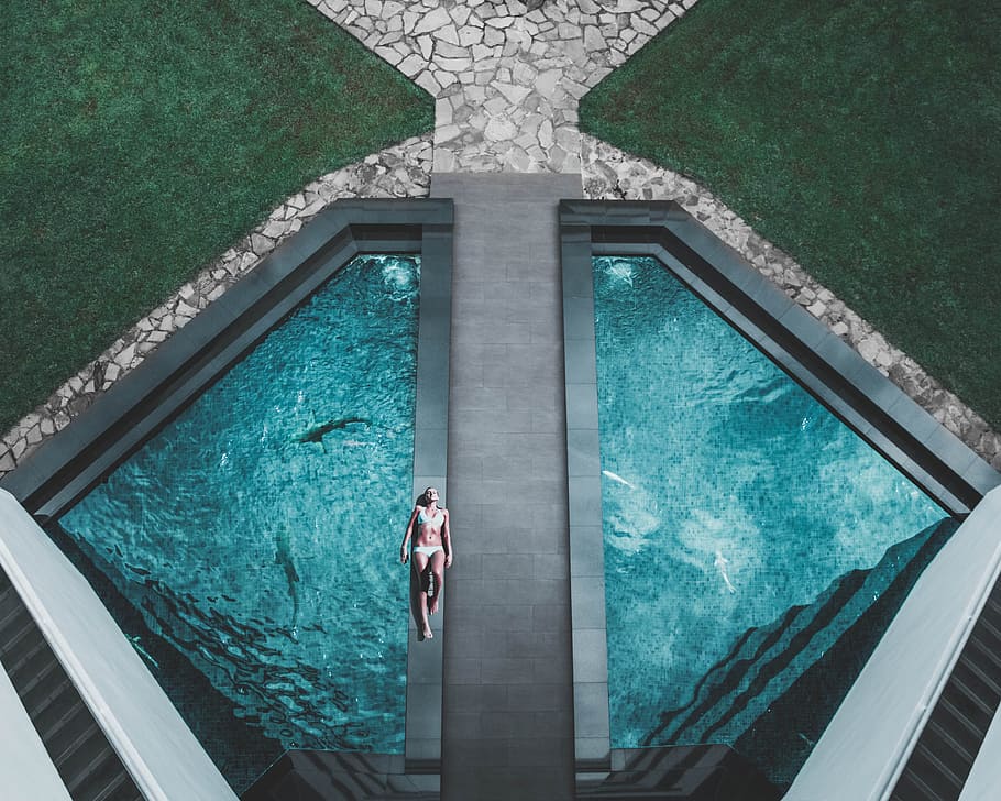 bird's eye view of woman lying on floor beside swimming pool, aerial photography HD wallpaper