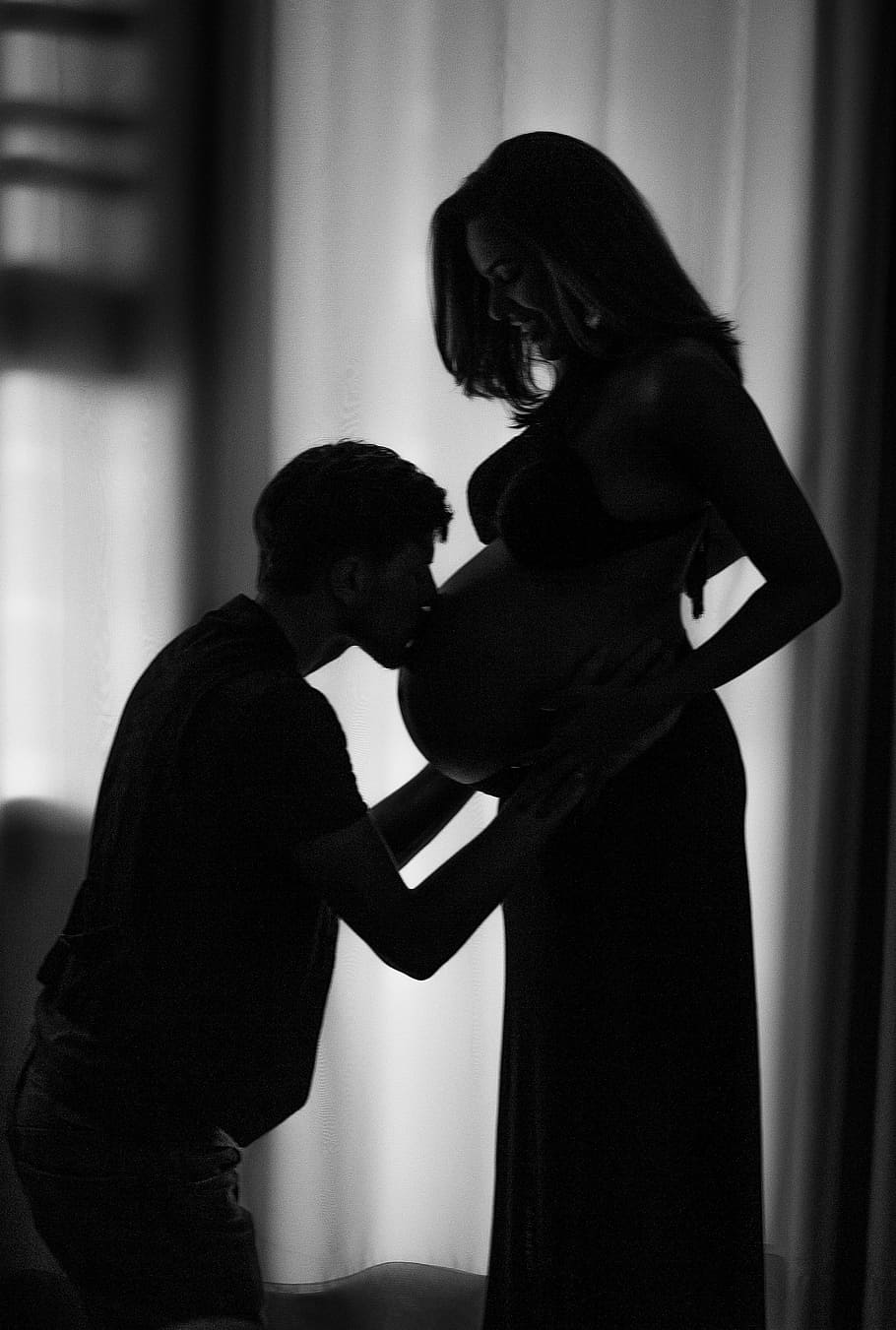 man wearing black crew-neck shirt kissing woman pregnant belly, HD wallpaper