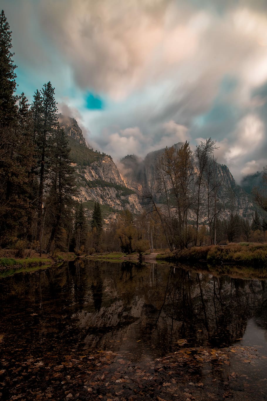 glacier mountain beside pine trees reflection on body of water under gray cloudy sky at daytime, photo of body of water surrounded by trees near mountaing HD wallpaper