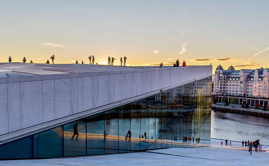 The Opera House, Oslo, people standing on top of building during sunrise