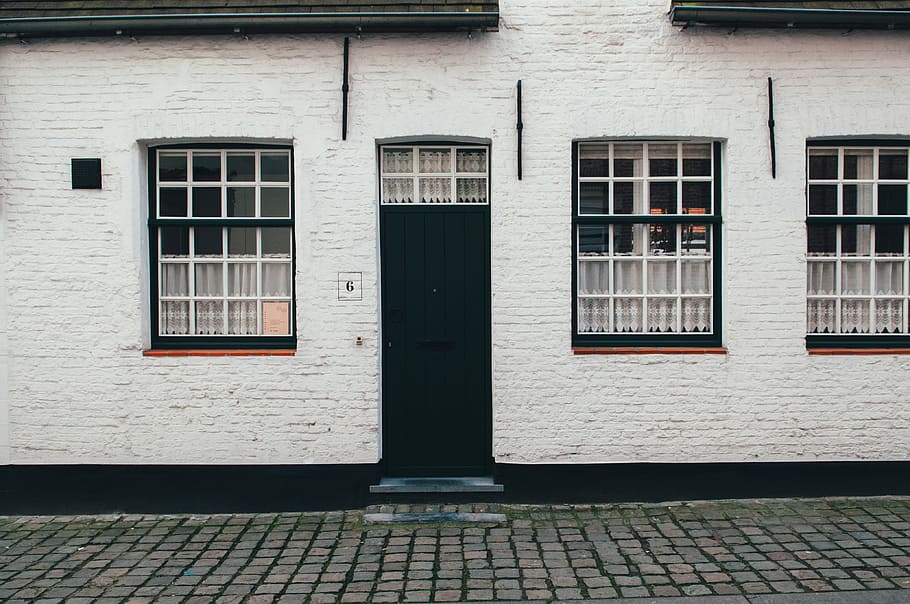 photo of white concrete house, closed door and window concrete house at daytime HD wallpaper