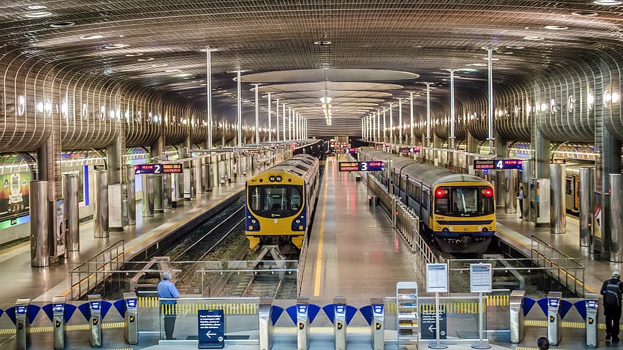 two yellow trains on train rails, terminal station, platform HD wallpaper
