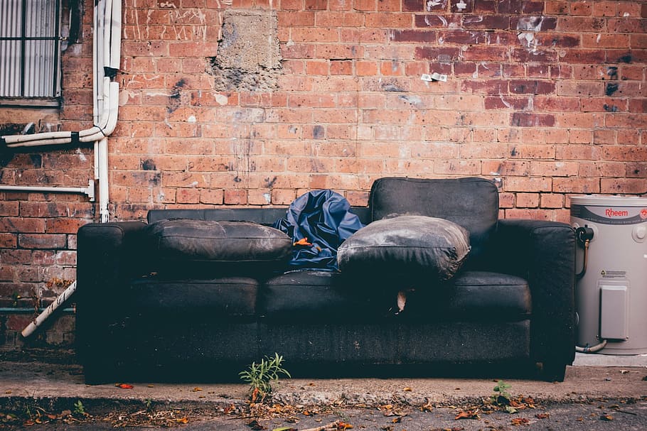 black 3-seat sofa beside brick wall, leather, gray, water, heater