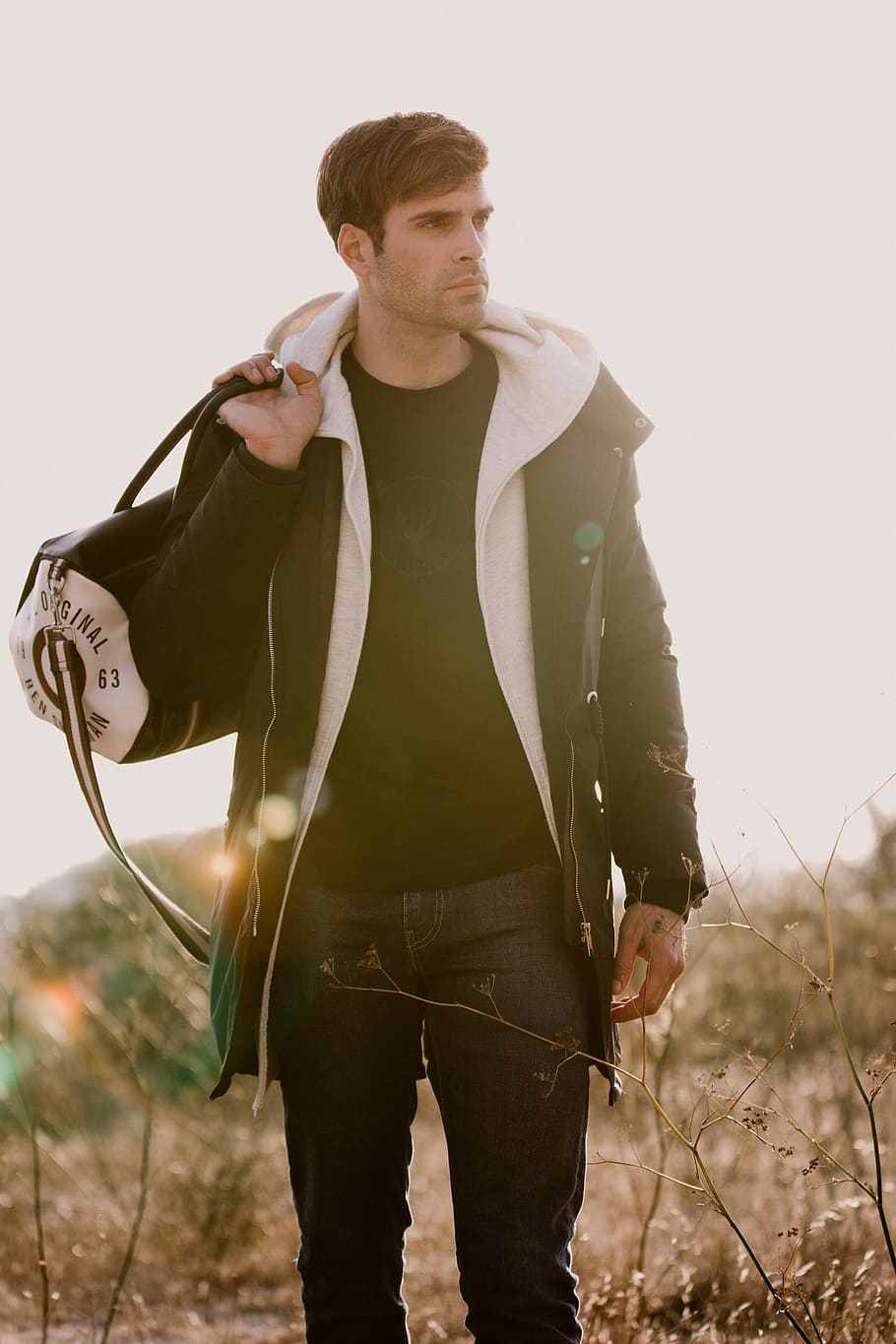 man holding a duffel bag, man holding duffel bag, person, sunlight HD wallpaper