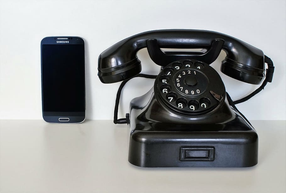 black rotary dial telephone and black Samsung Galaxy Android smartphone on white surface, HD wallpaper