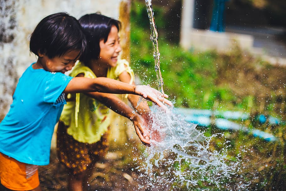 two girls playing water while standing during daytime, kids, youth