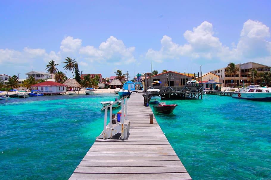 boat beside brown wooden dock, Belize, San Pedro, Tropical, Caye