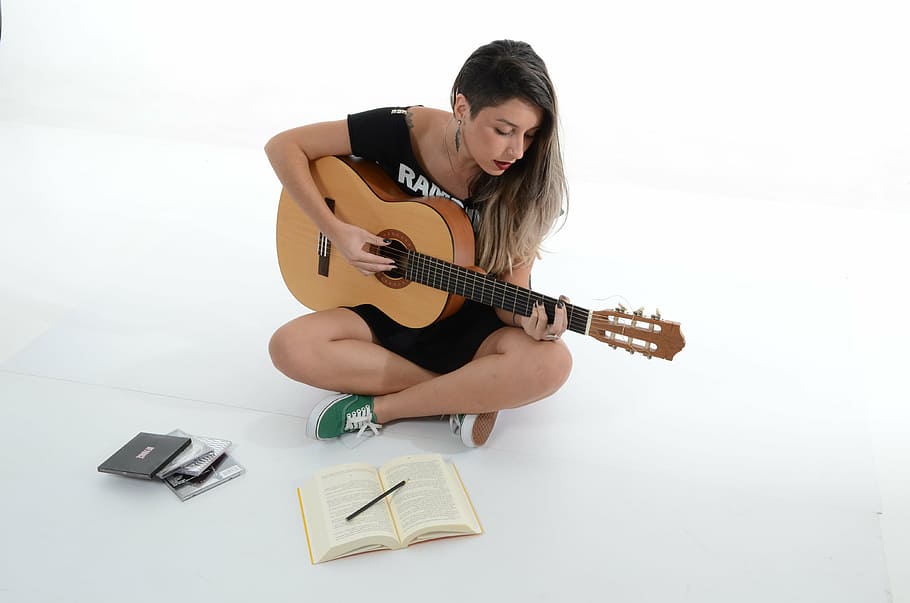 woman playing guitar inside white painted room, sing, music, rock