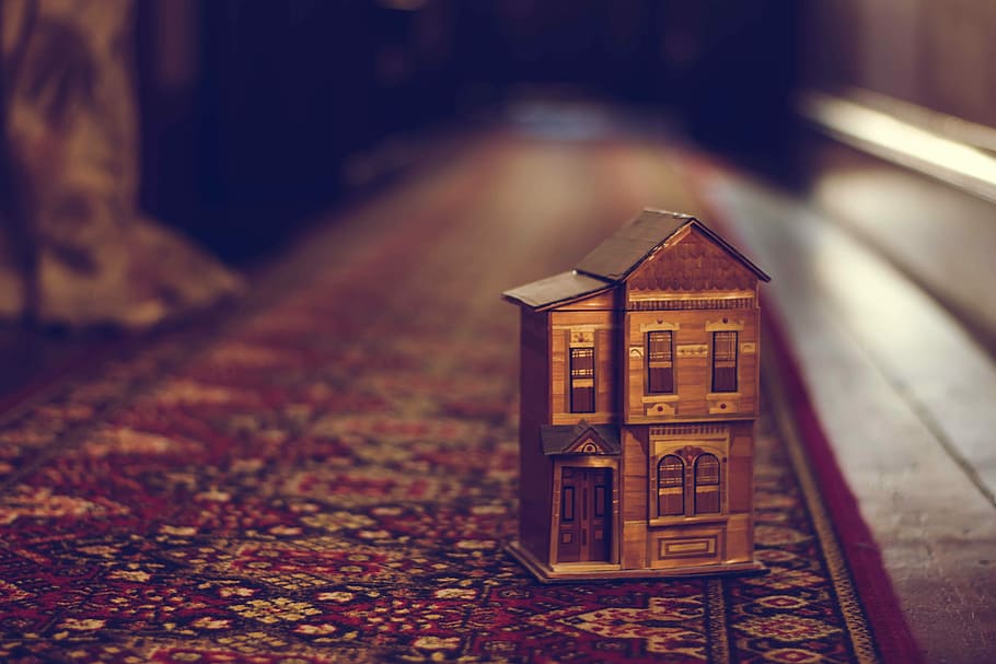 brown wooden house miniature on red carpet, brown house miniature on floor