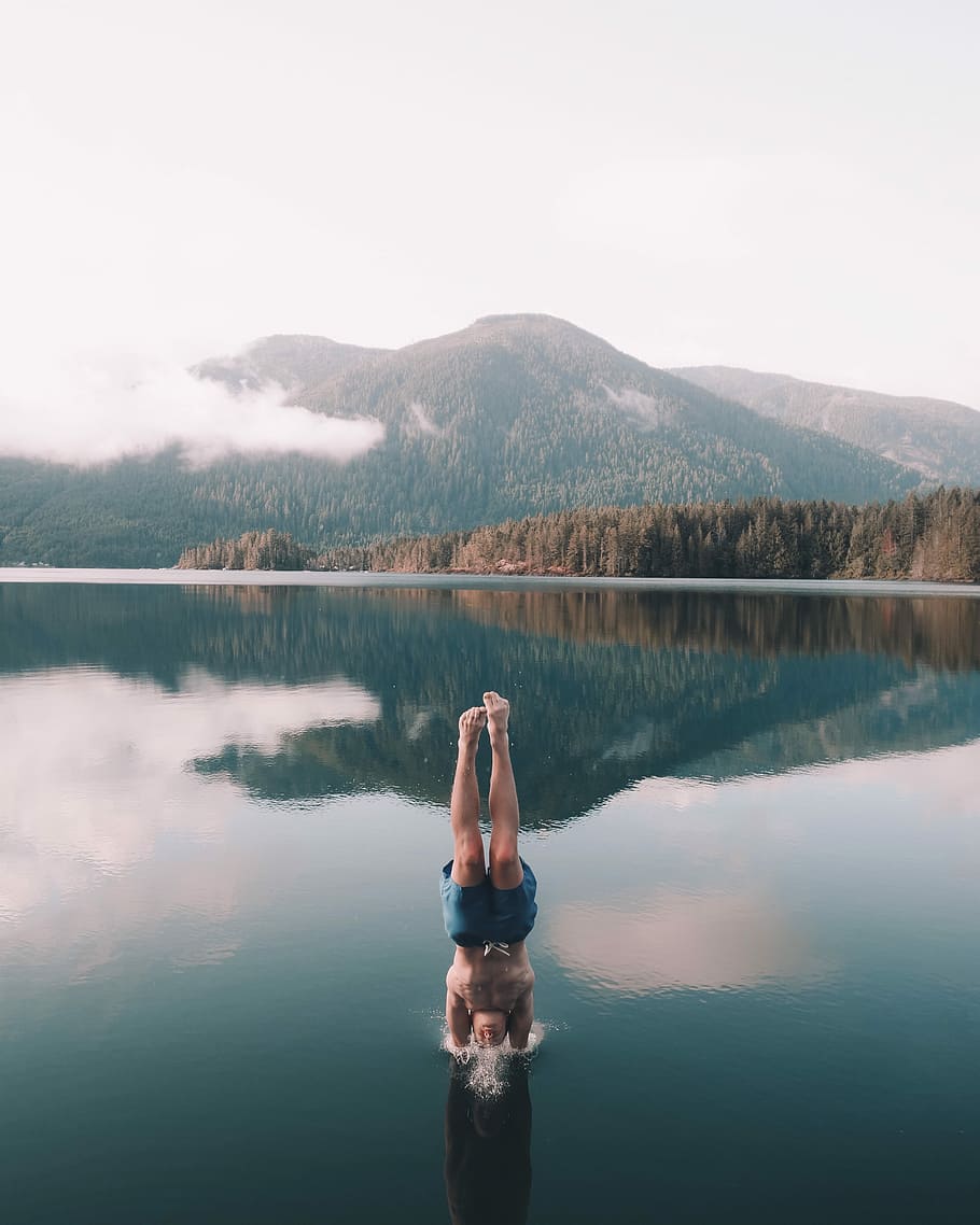 man diving on body of water, person in blue shorts diving on body of water HD wallpaper
