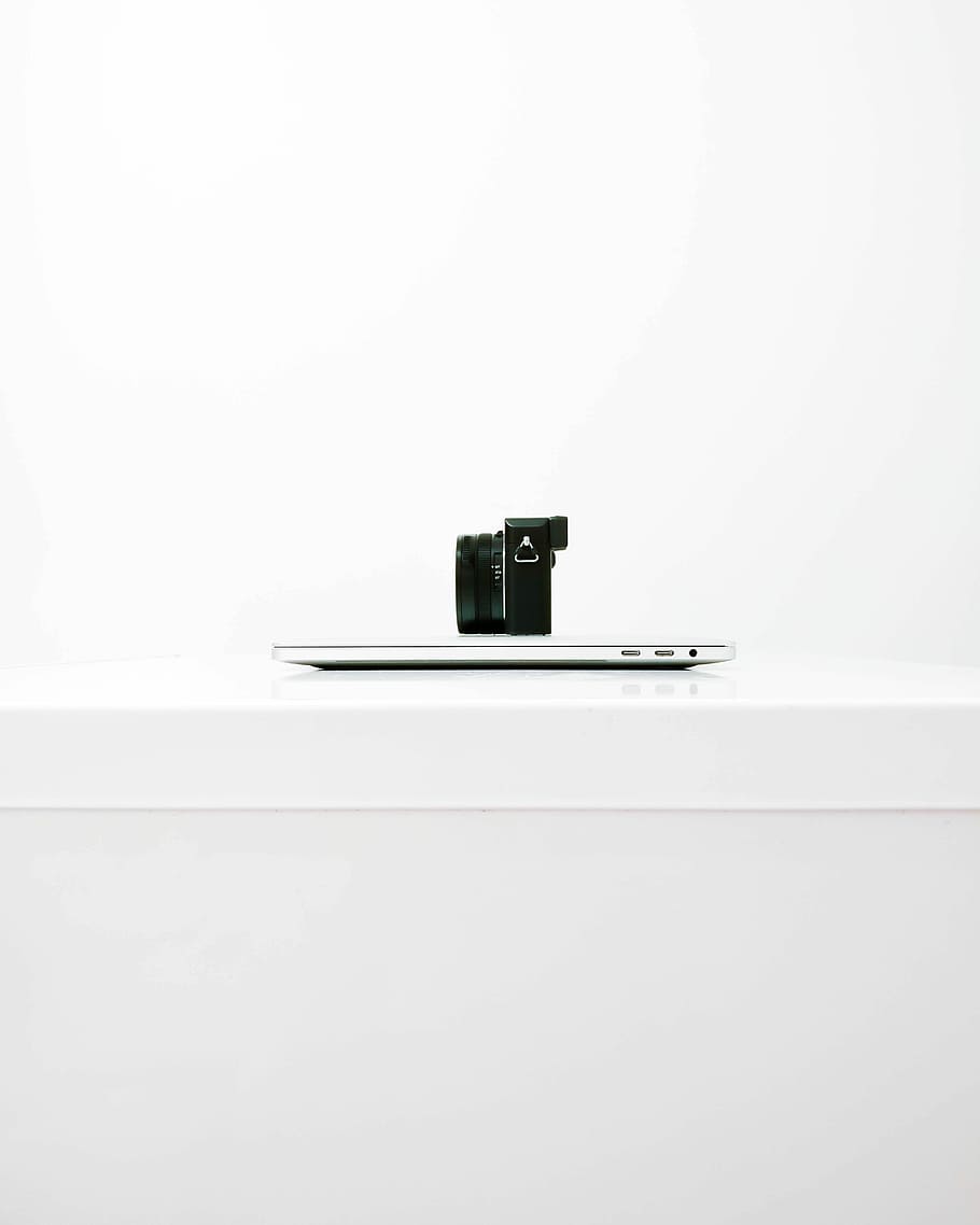 black mirrorless camera on top of MacBook, Macbook Air on white table HD wallpaper
