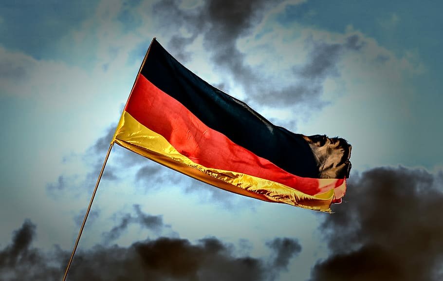 Germany flag under cloudy sky during daytime, dramatic, windy