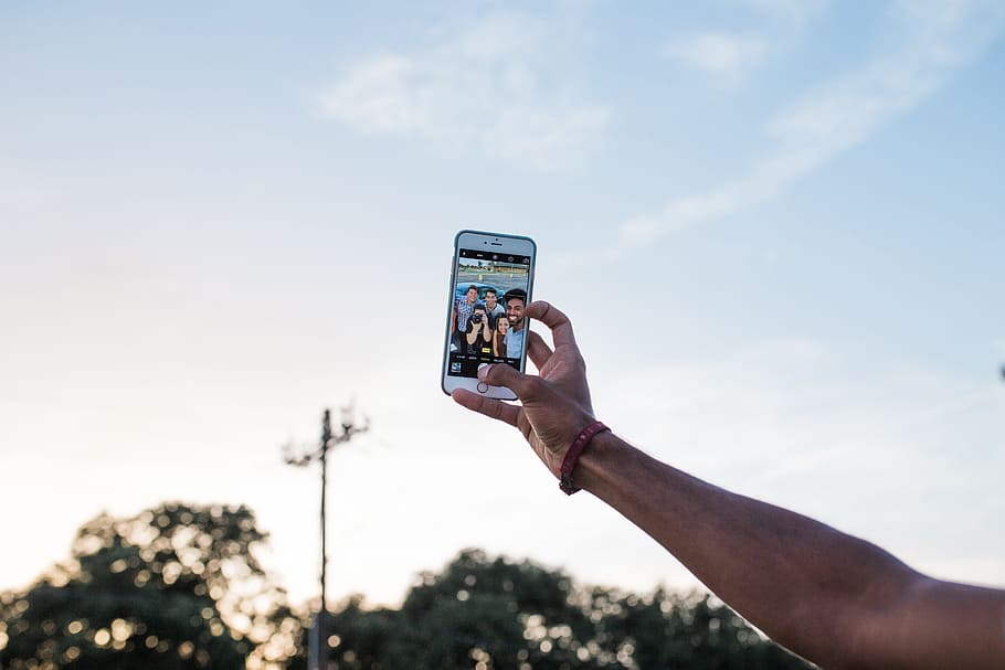 A man taking a selfie with his iPhone mobile smartphone, technology HD wallpaper