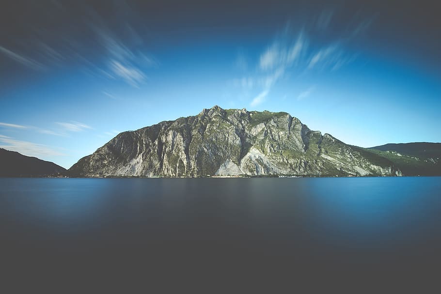 photo of mountain facing body of water, landscape photo of gray mountain near body of water HD wallpaper