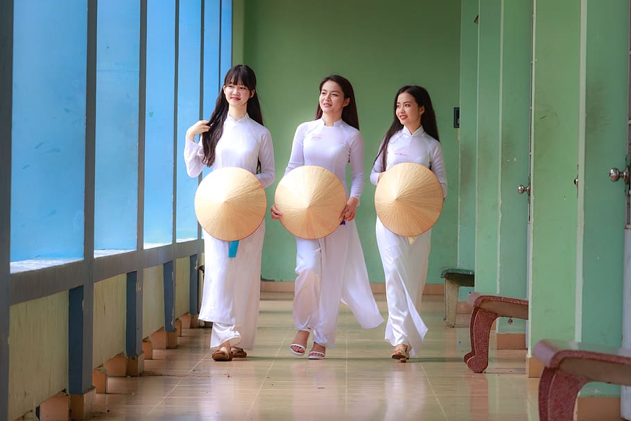 photo of three women wearing white long-sleeved dresses, vietnam