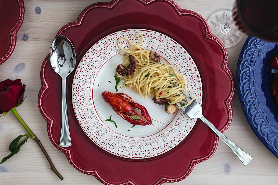 Fancy dinner with seafood pasta, crayfish and red wine by the table decorated with roses HD wallpaper