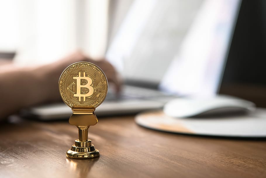 gold-colored bitcoin on brown table, gold-color Bitcoin on brown surface HD wallpaper