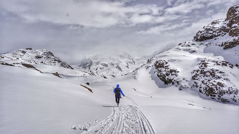 person walking on snowy mountain, person waling on snow covered trail HD wallpaper