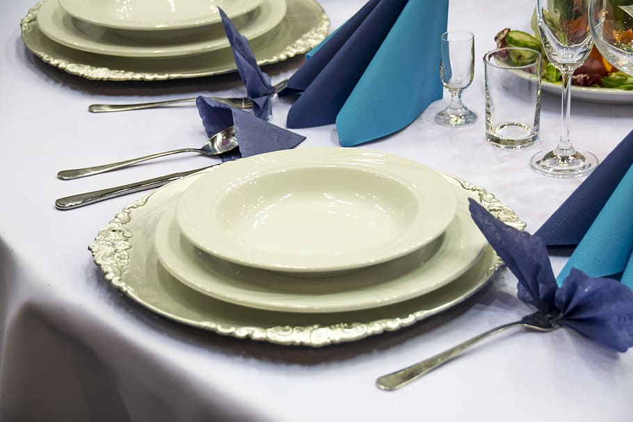round white ceramic plate on table with spoon and fork, table setting