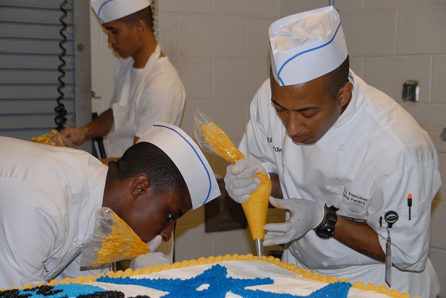 two men putting icing on cake, kitchen, decorating, preparing HD wallpaper