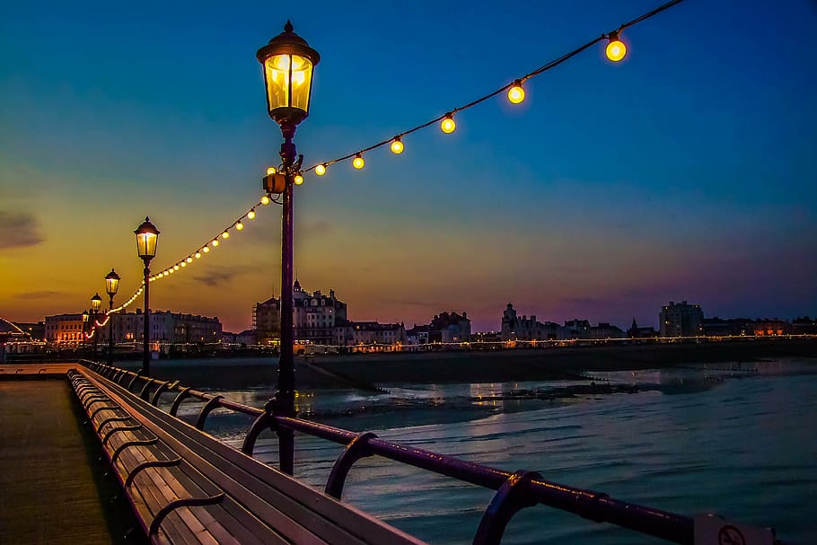 photo of outdoor lanterns beside sea, brighton pier, night, ocean