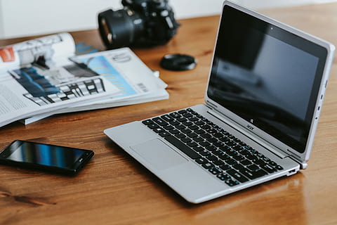 Silver laptop with various items on a table, magazines, computer HD wallpaper