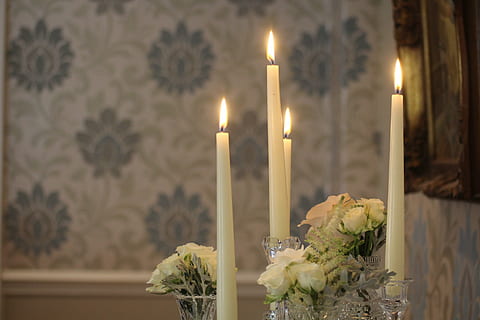 lighted white taper candles beside white rose flowers bouquets HD wallpaper