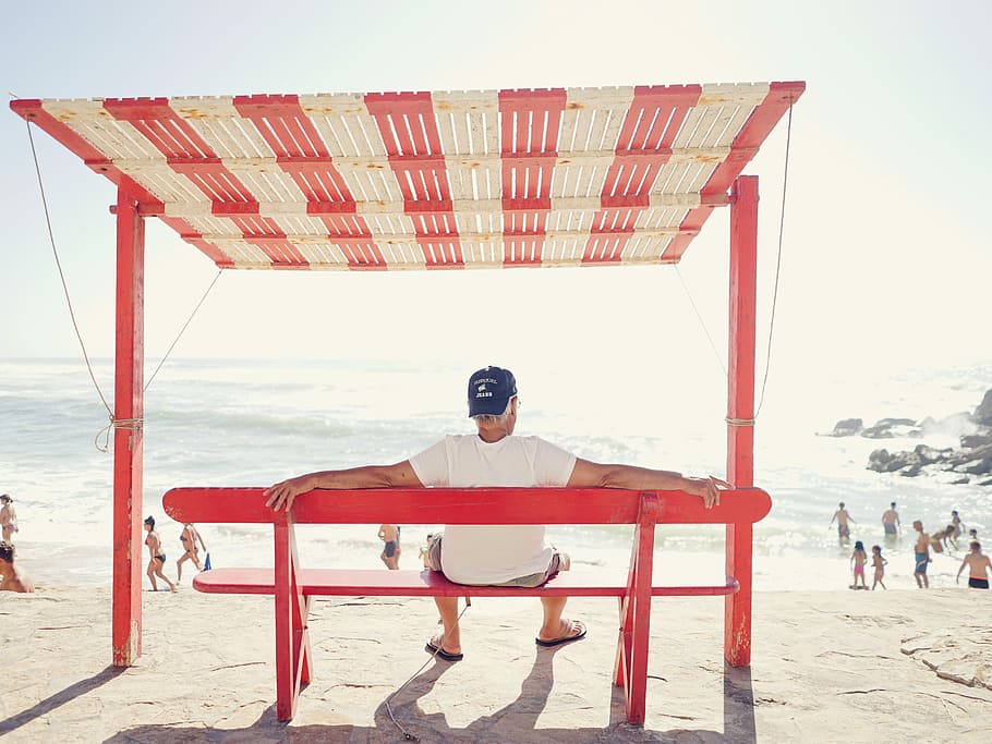 man sitting on bench near beach, man sitting on bench facing seashore HD wallpaper