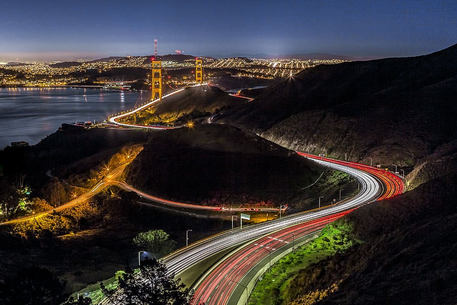 aerial shot of Golden Gate, aerial view timelapse photo of vehicles on road near brown hills leading to city HD wallpaper